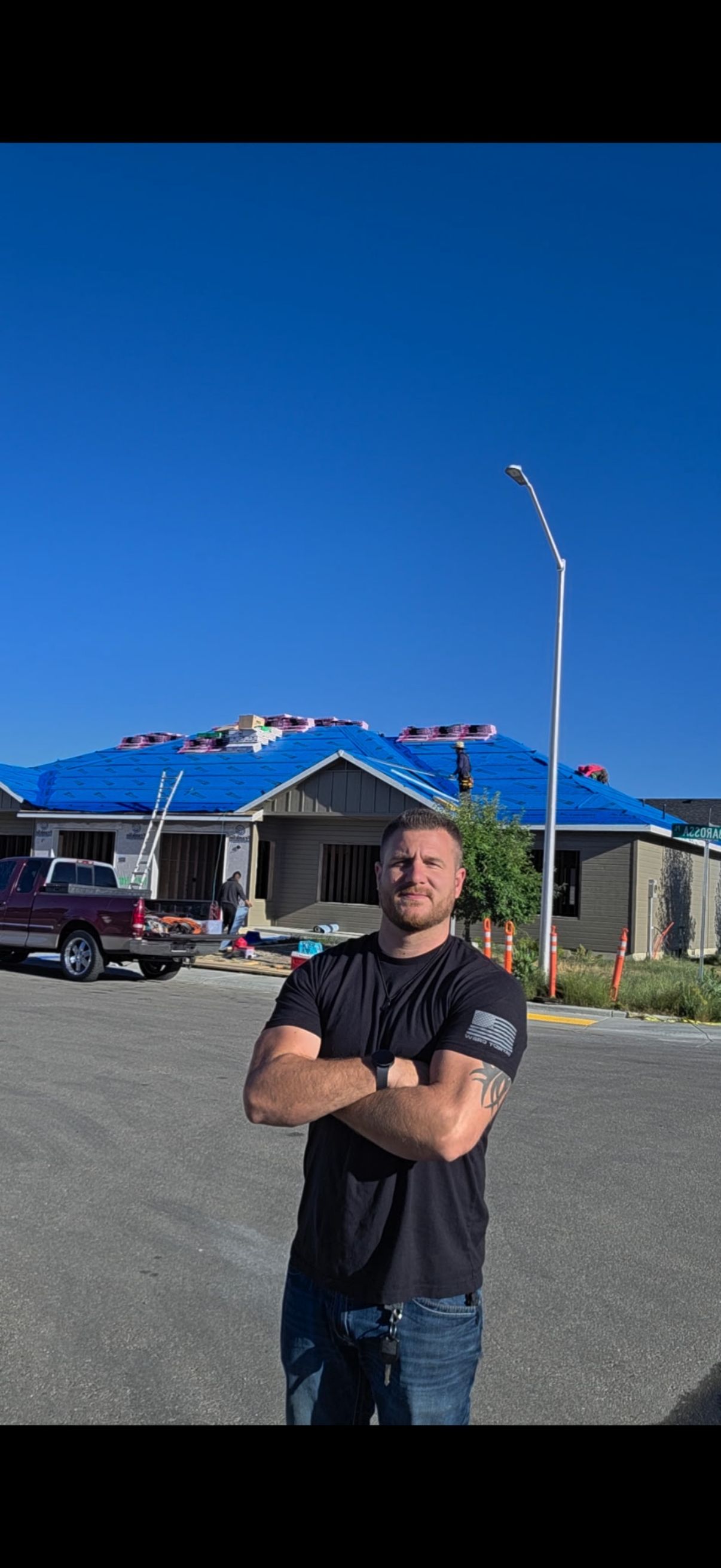 A crew member at a fully tarped roof