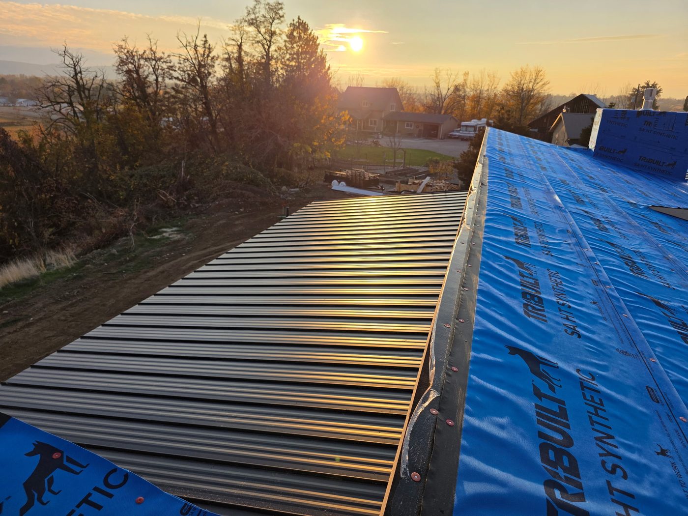 Standing seam metal roof panels at sunset on a new construction home