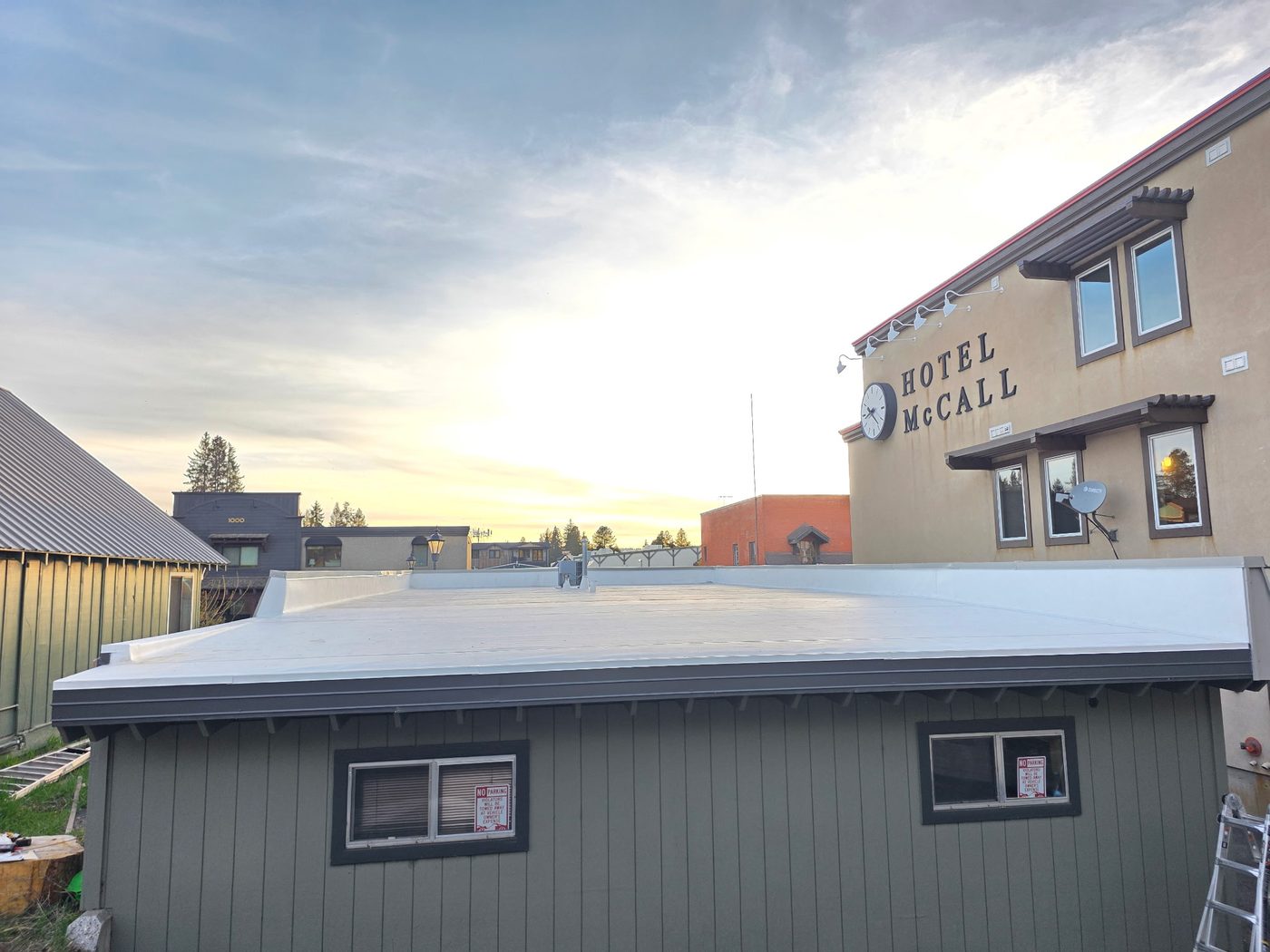 Completed TPO flat roof at sunset with custom fascia metal