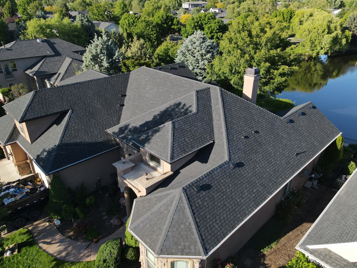 Aerial view of a completed architectural shingle roof replacement on a large custom waterfront home in the Treasure Valley