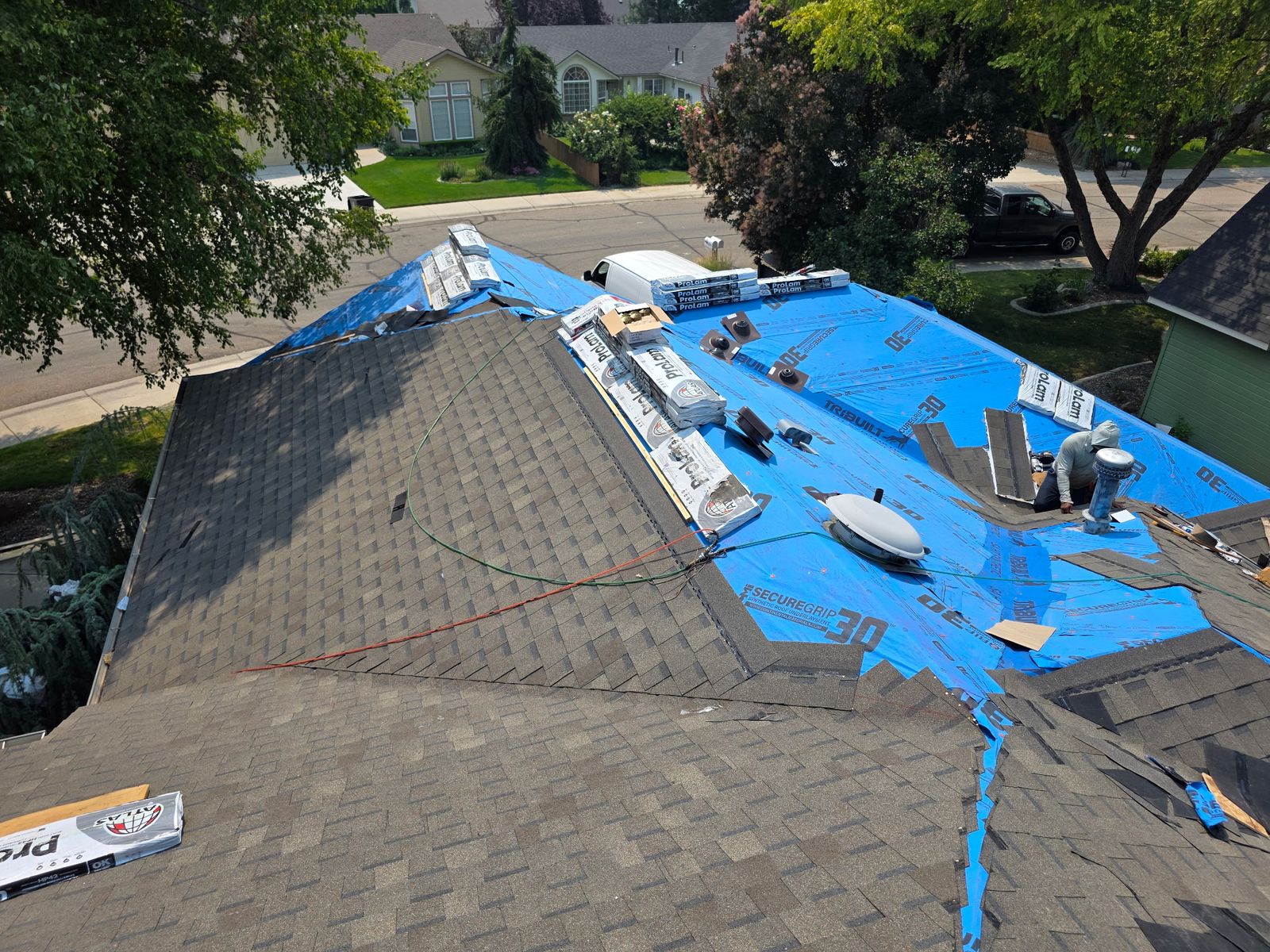 A storm-damaged roof under a tarp while the claim is documented