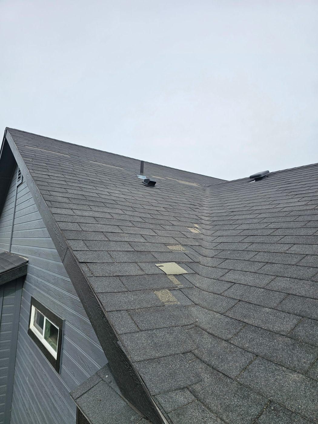 Wind claim: shingle tabs torn off a roof slope, underlayment patches exposed