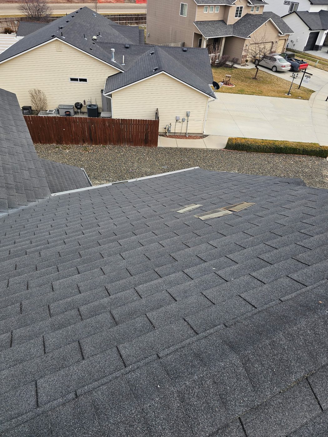 Wind claim: missing shingles along a roof valley, photographed for claim documentation